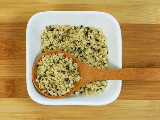 Geschälte Hanfsamen in einer Schale mit Holzlöffel